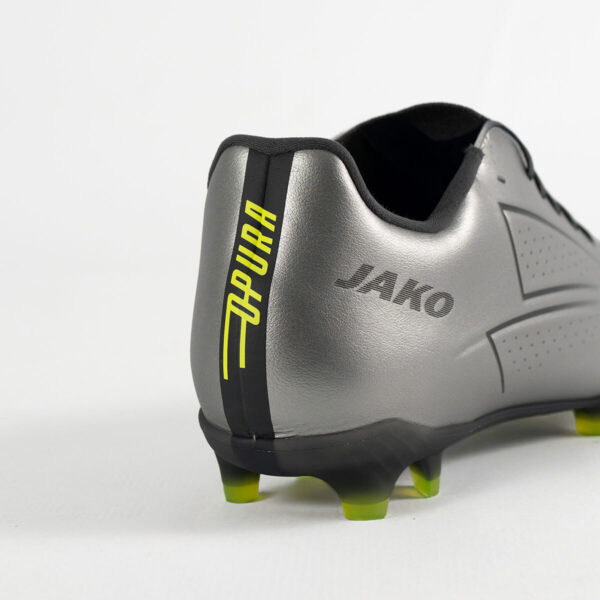 5552_677_P08 Close-up of a silver JAKO soccer boot heel with a black stripe, lime-yellow studs, and branding visible on the side.