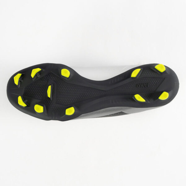 5553_677_P05 Bottom view of a black soccer cleat with neon yellow studs arranged for firm ground play.
